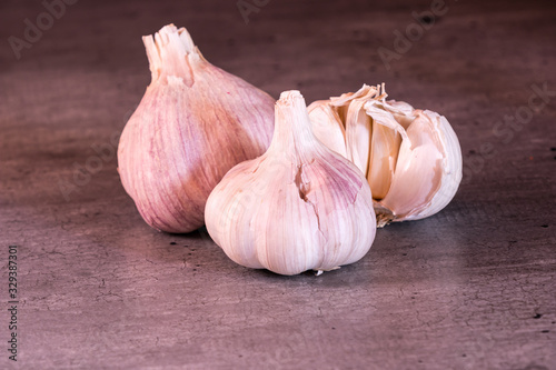 three large heads of pink garlic on a kitchen worktop