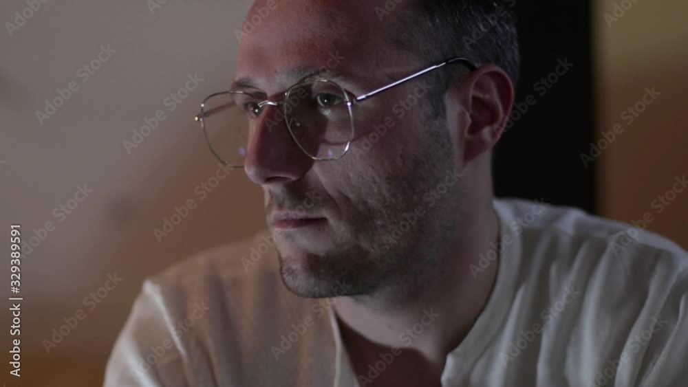 Thinking man. Young person with glasses sitting in solitude. Sorrow. Anxiety. Depression. Thinking man. Young person with glasses sitting in solitude. Sorrow. Anxiety. Depression.