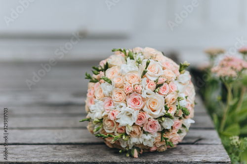 Wedding bouquet of colorful roses close-up on a wooden background. Photography, concept.