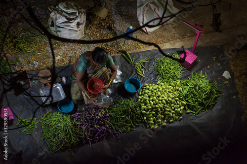 Market stall with woman selling vegetables in India