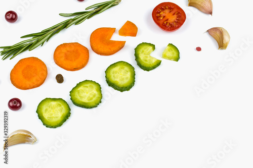 Fototapeta Naklejka Na Ścianę i Meble -  A branch of rosemary, sliced carrots and cucumber, garlic and cranberries isolated on a white background.