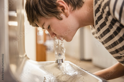 School kid drinking from water fountain. Red Lodge, Montana, USA photo