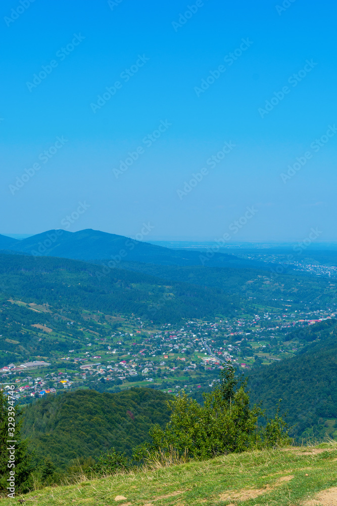 Photo of settlement in the Carpathian valley at summer day in mountains