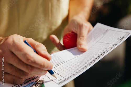 Midsection of player filling score card at golf course