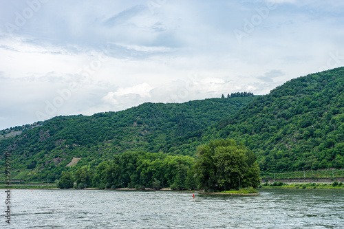 Germany, Rhine Romantic Cruise, a body of water with a mountain in the background © SkandaRamana