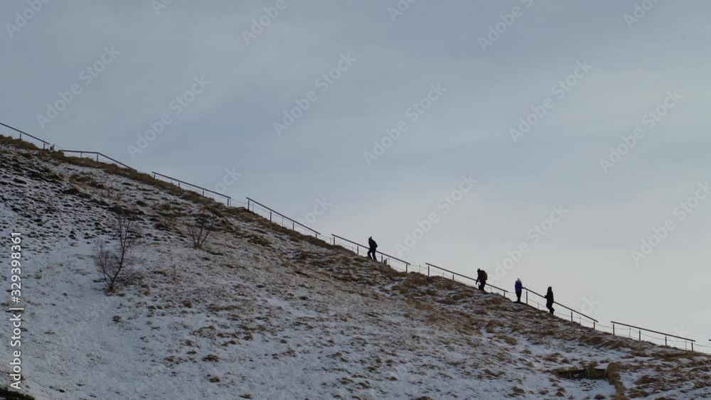 Determined people hiking up to top of mountain on a winter day in south Iceland. Determined people hiking up to top of mountain on a winter day in south Iceland.