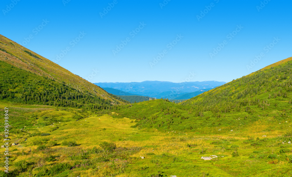 Photo of green meadows and hills at summer day in Carpathian mountains Photo of green meadows and hills at summer day in Carpathian mountains