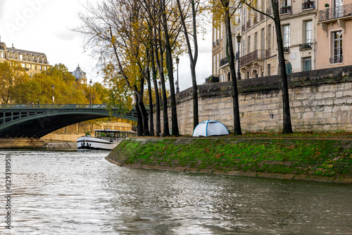 Tent on river Seine embankment next to residential houses in central Paris, France