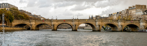 Scenic arches of Pont Neuf bridge and Paris cityscape while cruising on river Seine, France