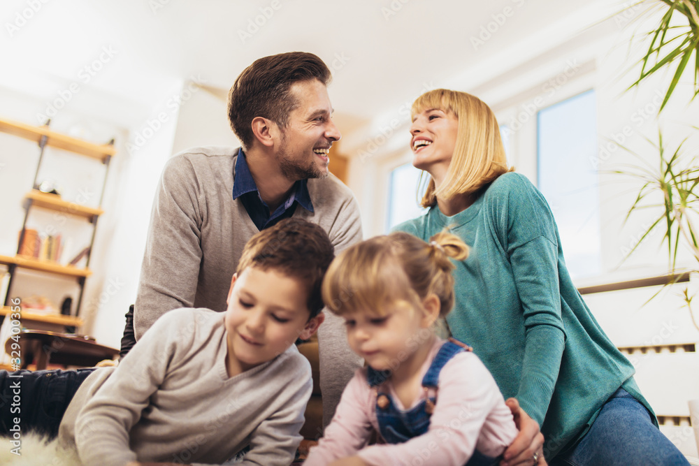 Happy family having fun on floor of in living room at home, laughing.Selective focus.