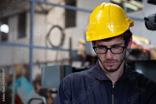 Portrait of industrial engineer wearing hard hat while standing in the heavy Industry manufacturing factory © comzeal