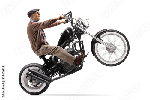 Grandfather riding a chopper motorbike on one wheel