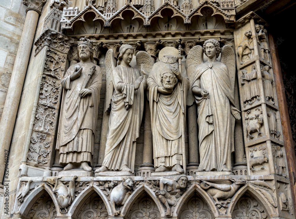 Martyr Saint Denis holding his head over the Portal of the Virgin, Notre-Dame de Paris cathedral, Paris, France