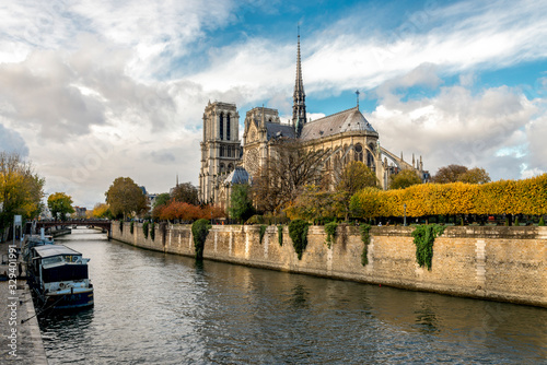 A scenic view of Seine river embankment and Notre-Dame de Paris cathedral in autumn season, Paris, France