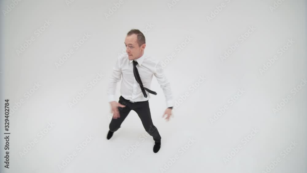 Top view of a businessman dancing a break dance and looking at the camera. The office worker guy dancing break dance looking up Top view of a businessman dancing a break dance and looking at the camera. The office worker guy dancing break dance looking up