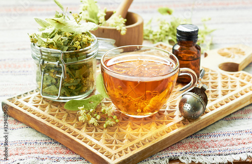 Canvastavla Linden herbal tea with lime tree bloom and glass can with dried herb nearby on r