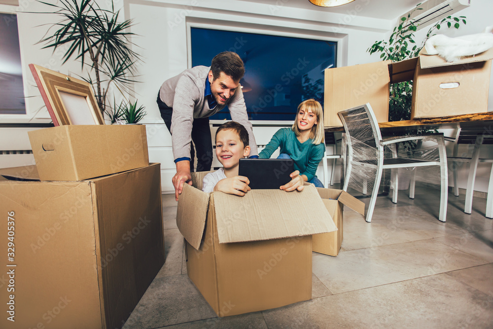 Happy family moving home with boxes around Happy family moving home with boxes around