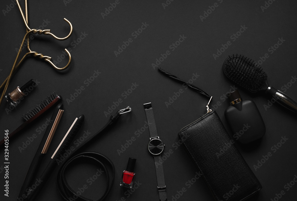 Accessories for women's beauty. Make up brush,watch,perfume bottle,hanger,wallet,nail polish, comb,belt all on a black background with top view and copy space. Minimal black 2020 trends Flat lay. Accessories for women's beauty. Make up brush,watch,perfume bottle,hanger,wallet,nail polish, comb,belt all on a black background with top view and copy space. Minimal black 2020 trends Flat lay.