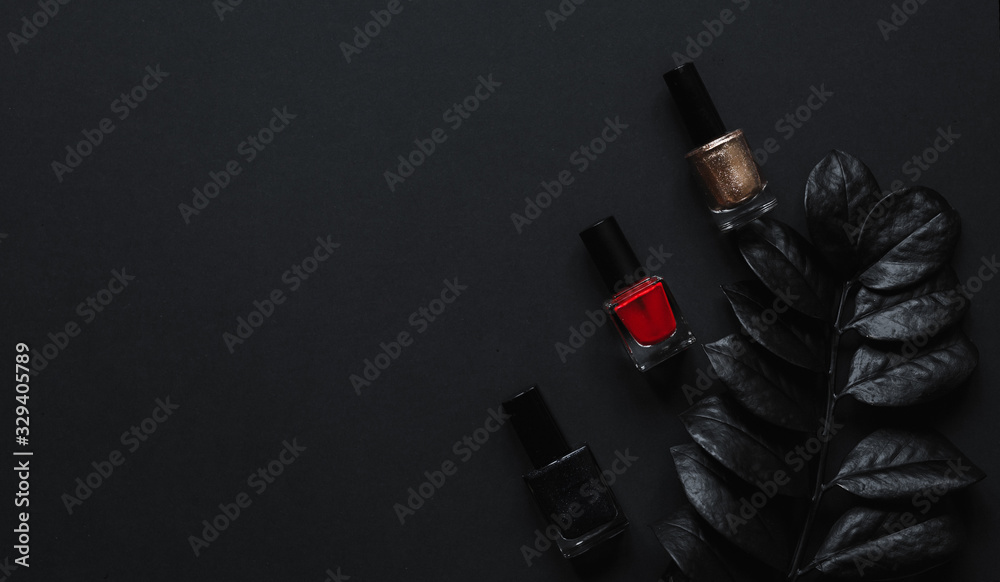 Fototapeta Red, golden and black Nail polish and luxury leaf on a black background with top view and copy space. Minimal black trendy 2020. Cosmetics concept Flatlay.