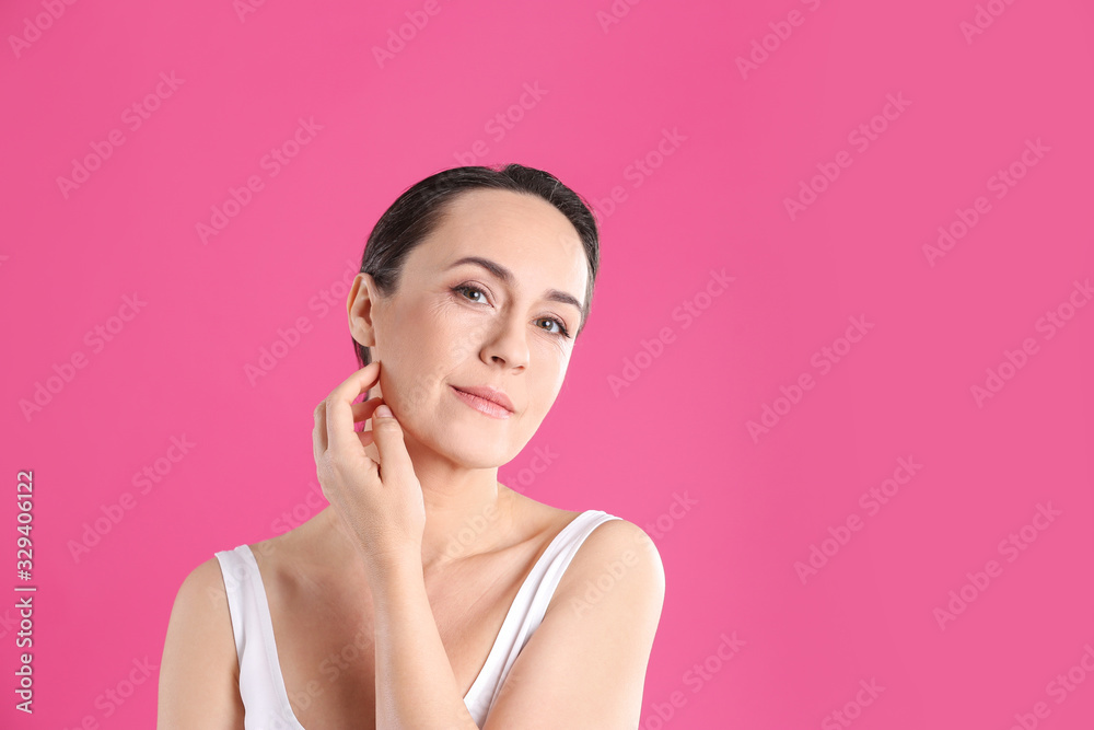 Portrait of beautiful mature woman on pink background. Space for text Portrait of beautiful mature woman on pink background. Space for text