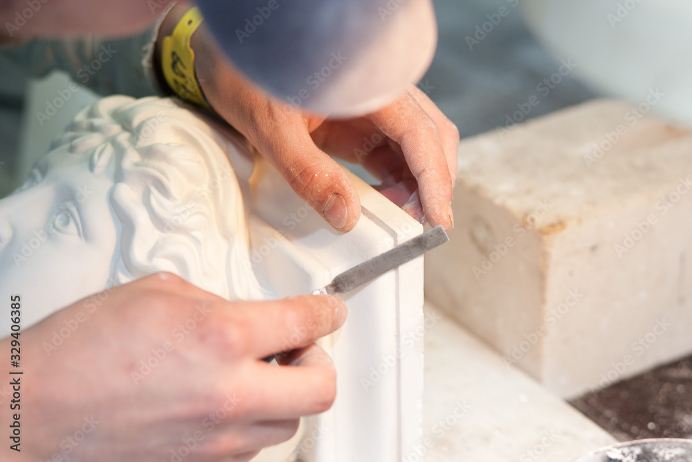Ein Stukkateur restauriert eine Stuck Figur Ein Stukkateur restauriert eine Stuck Figur