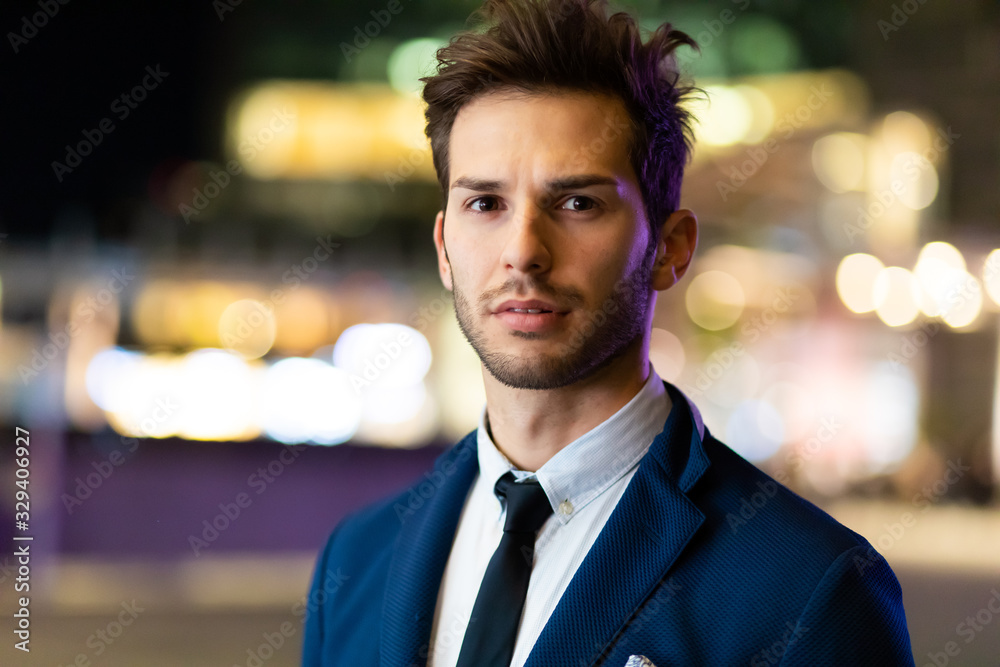 Young businessman outdoor in a modern city setting at night