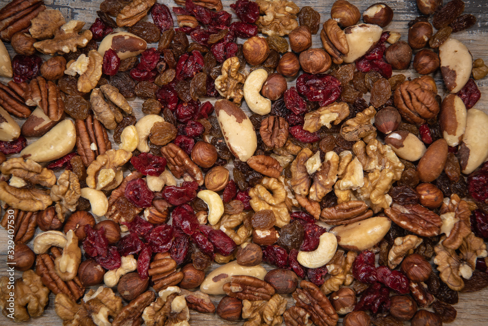 Mixed nuts and dried fruits in wooden bowl on wood background, copy space Mixed nuts and dried fruits in wooden bowl on wood background, copy space