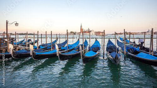 Gondolas moored by Saint Mark square with San Giorgio di Maggiore church, Venice © k_samurkas