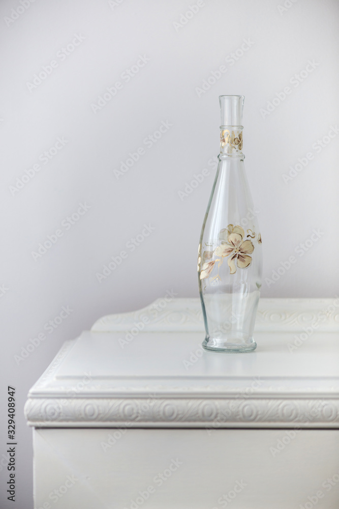 painted glass bottle over an antique wooden cabinet - home decoration - selective focus, copy space