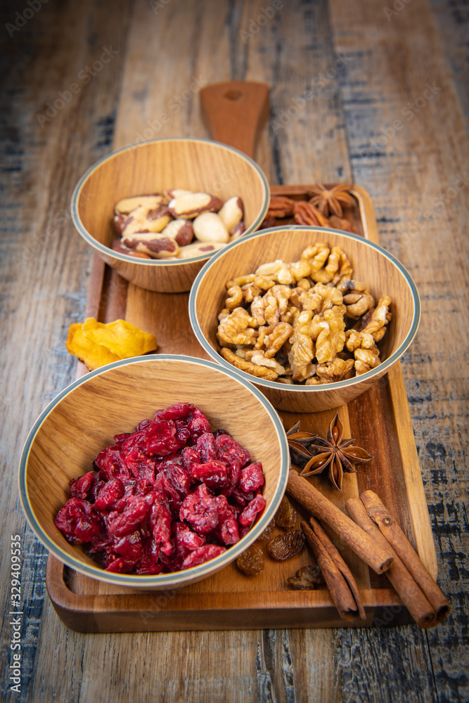 Mixed nuts and dried fruits in wooden bowl on wood background, copy space Mixed nuts and dried fruits in wooden bowl on wood background, copy space
