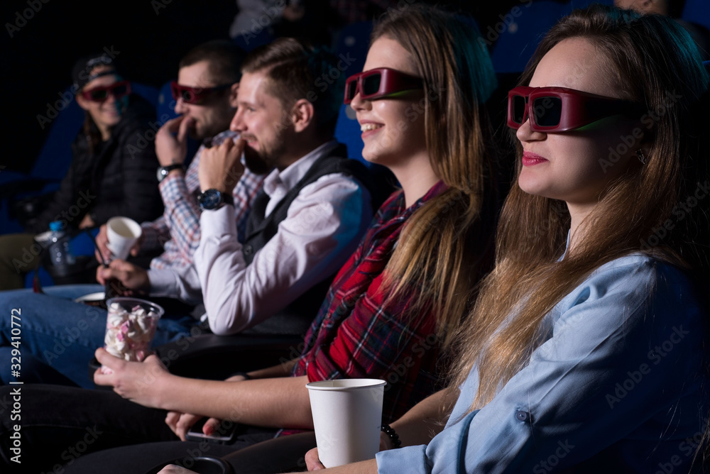 general plan of young people of different sexes, from nineteen to thirty years old, sitting on the seats in the cinema, watching a movie with glasses for 3D. Generation Z, Generation Y, Millennials.