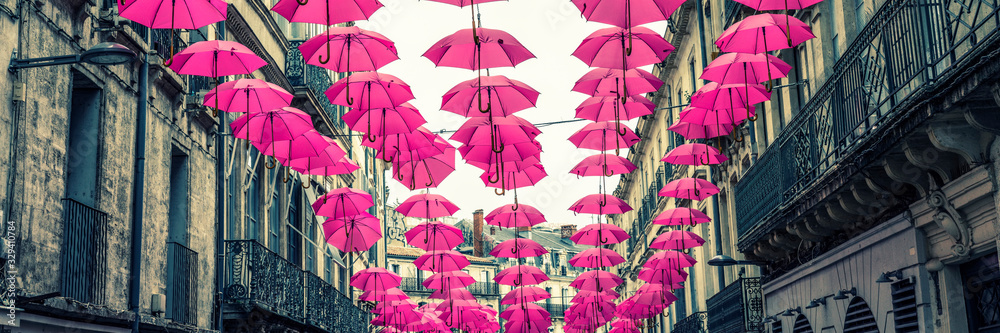 Naklejka premium różowe parasole na ulicy