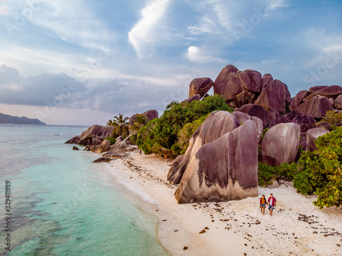 Seychelles tropical islands, Praslins Island Seychelles with couple walking on the tropical beach with palm trees photo