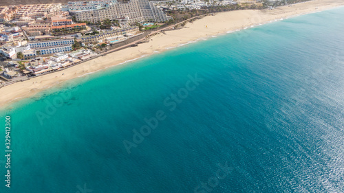 Fototapeta Naklejka Na Ścianę i Meble -  Morro Jable Canary Island, Fuerteventura Spain, Aerial view on coast of atlantic ocean and beach, Drone shot of sea 