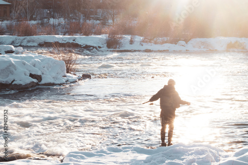 A man fly fishing on the bank of a river