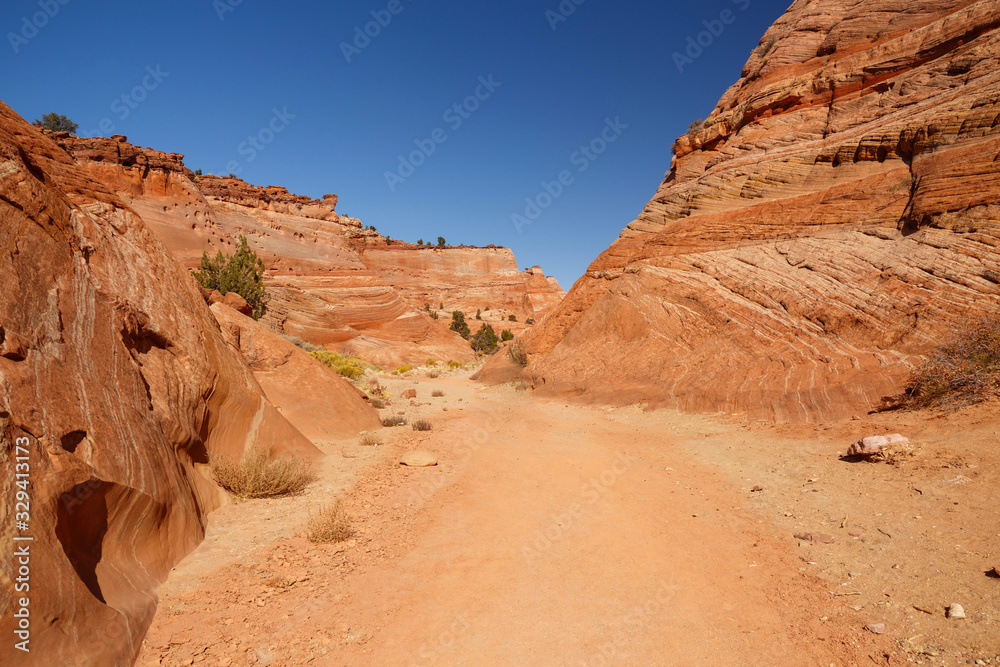 Rocks and Mountains along a trail to Tunnel Slot during sunny day with blue sky in Escalante National Monument,  Grand Staircase trail, Utah, USA