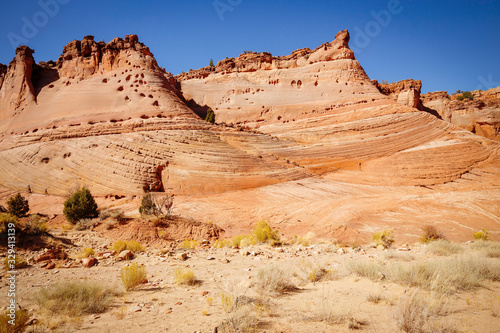 Rocks and Mountains along a trail to Tunnel Slot during sunny day with blue sky in Escalante National Monument, Grand Staircase trail, Utah, USA