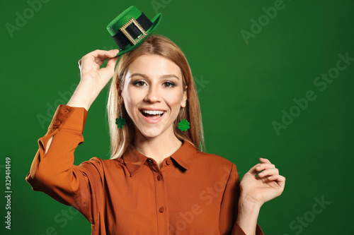 Young woman with leprechaun hat on green background. St. Patrick's Day celebration