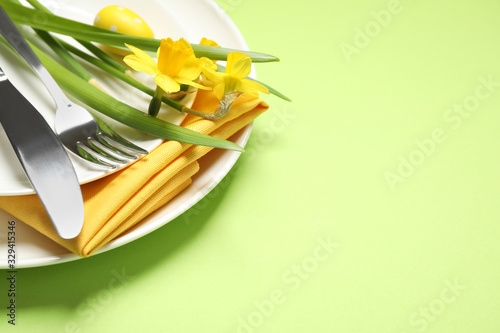 Festive Easter table setting with beautiful narcissuses  closeup. Space for text