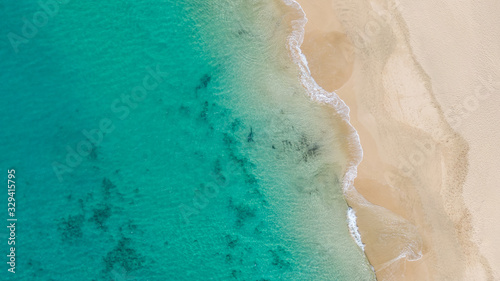 Top View on Coast of Atlantic Ocean, waves on beach aerial view, crystal clear water in Morro Jable Fuerteventura. 