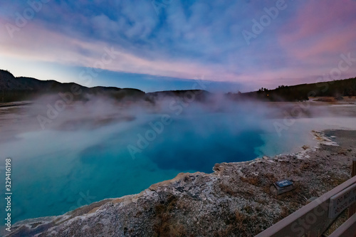 Sapphire Pool in Biscuit basin with blue steamy water and beautiful colorful sunset. Yellowstone, Wyoming, USA