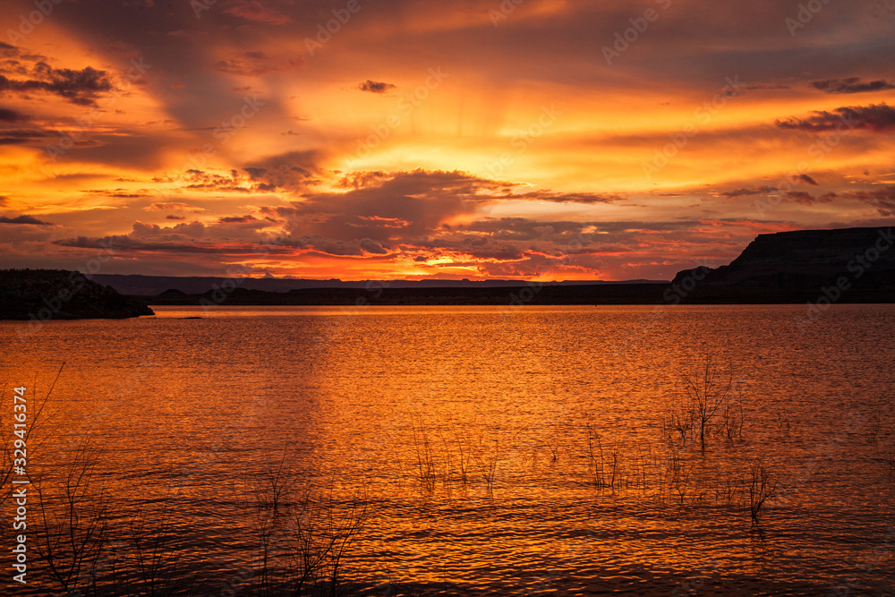 sunset creates red orange clouds over lake Powell