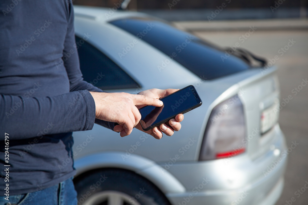 Young man holding a phone in his hands Young man holding a phone in his hands