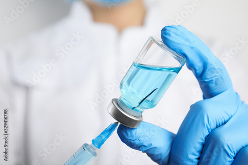 Doctor filling syringe with medication, closeup. Vaccination and immunization