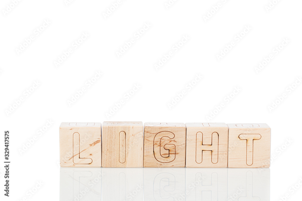 Wooden cubes with word light on a white background