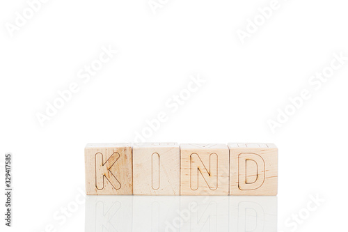 Wooden cubes with word kind on a white background