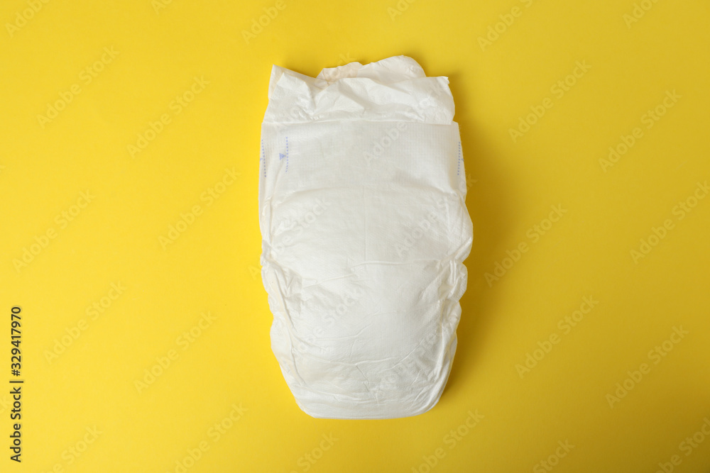 Baby diaper on yellow background, top view Baby diaper on yellow background, top view