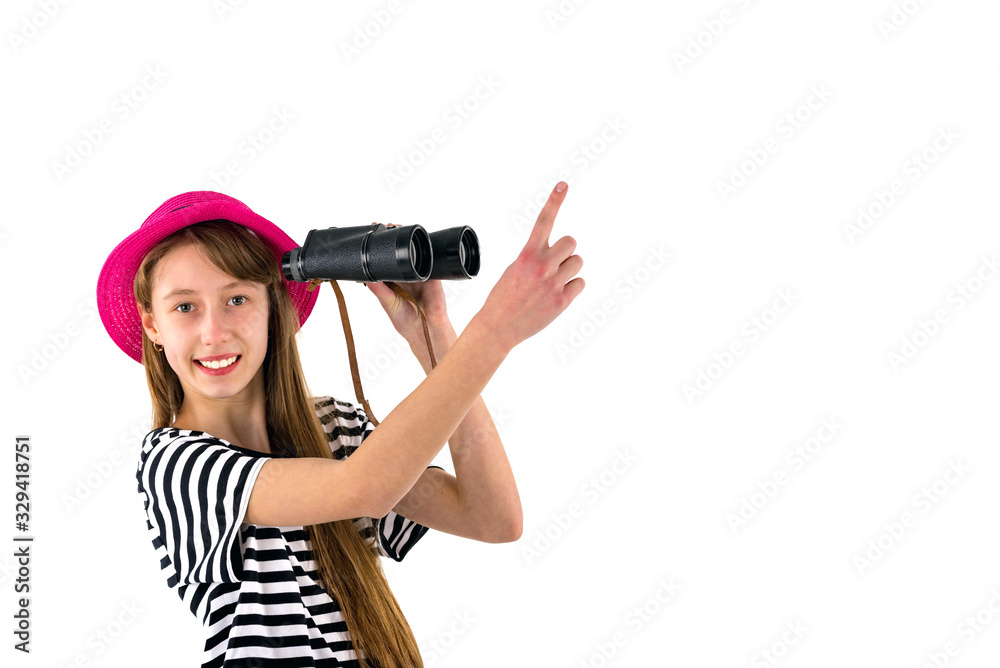 Trendy smiling slim long haired young caucasian teenage girl wearing casual clothes with binocular shows with finger in the blank space on isolated white background.,mock up banner.Summer concept. Trendy smiling slim long haired young caucasian teenage girl wearing casual clothes with binocular shows with finger in the blank space on isolated white background.,mock up banner.Summer concept.