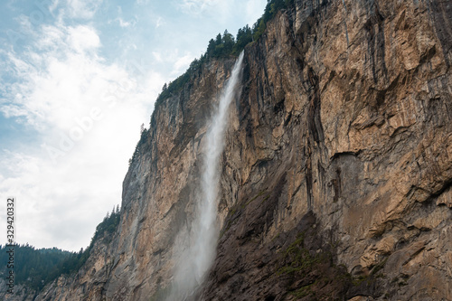 Small mountain waterfall. Summer alpine mountain landscape