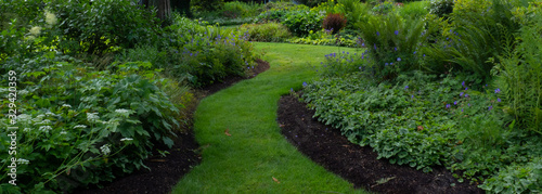 Winding grass path through lush Pacific Northwest garden in Summer